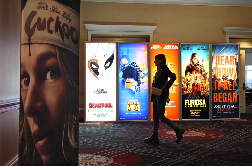 Một du khách đi ngang qua quảng cáo cho các bộ phim sắp ra mắt vào ngày khai mạc CinemaCon 2024 tại Caesars Palace, Mỹ.