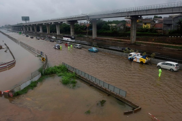 Những cơn mưa lớn khiến đường phố ở Bekasi hóa thành sông hồ - Ảnh: Reuters.