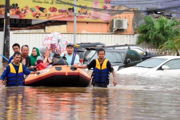 Đội cứu hộ dùng thuyền hơi đưa người dân ở Bekasi, gần Jakarta, đến nơi an toàn hôm 1/1 - Ảnh: Reuters.