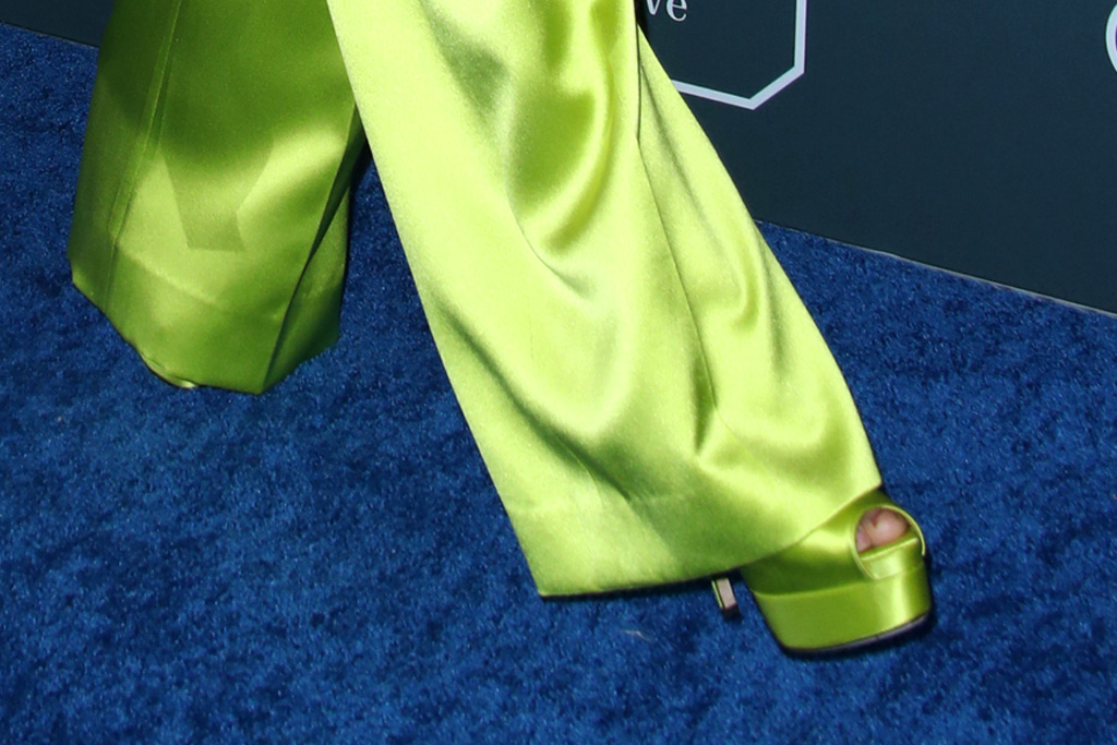 Nữ diễn viên kết hợp trang phục cùng clutch, hoa tai ánh bạc cùng giày cao đồng màu xanh. Bộ trang phục giúp Kristen Bell trông cao hơn nhiều so với chiều cao thực tế 1m55.