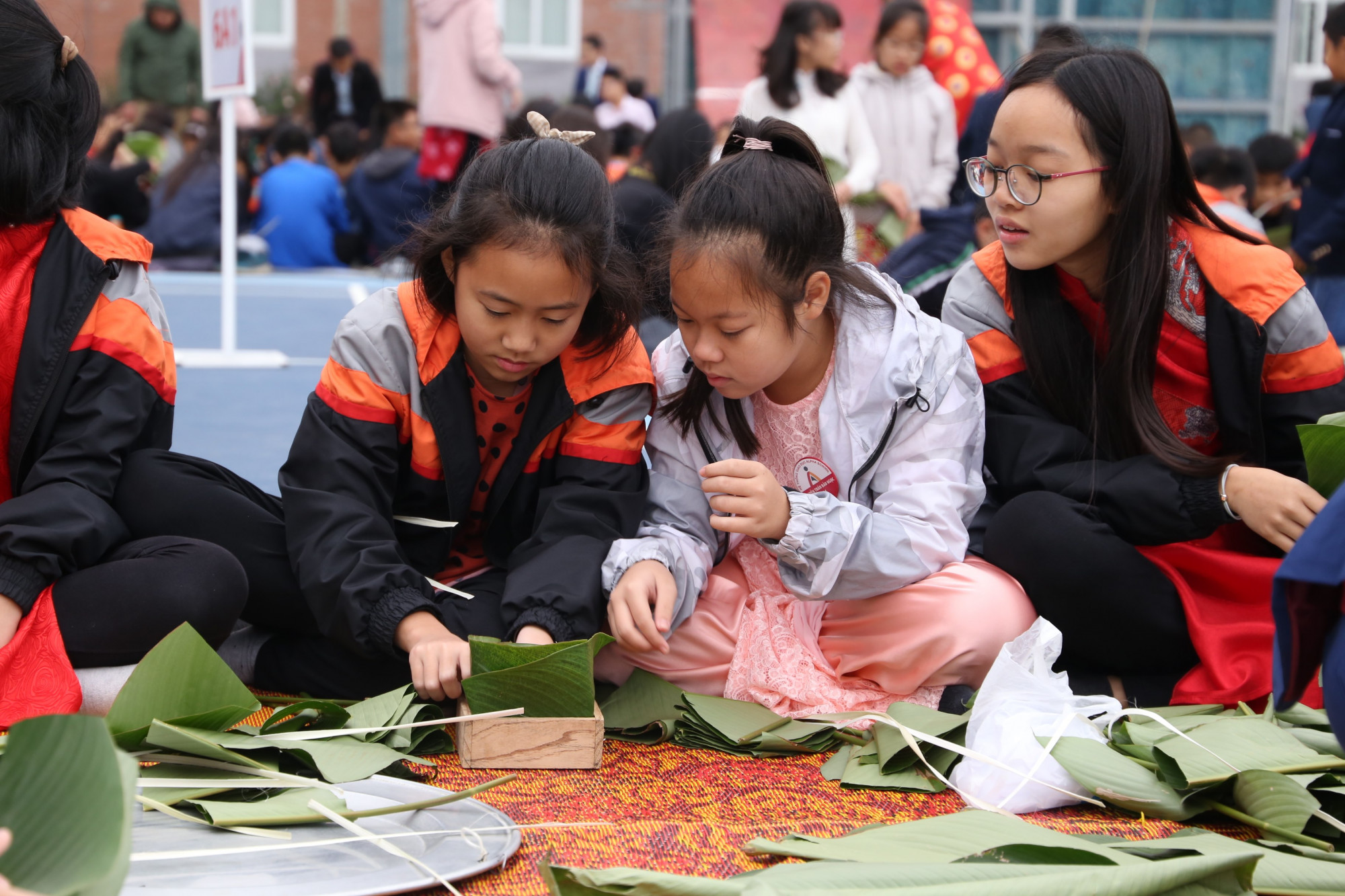 Các nữ sinh thực hành gói bánh chưng