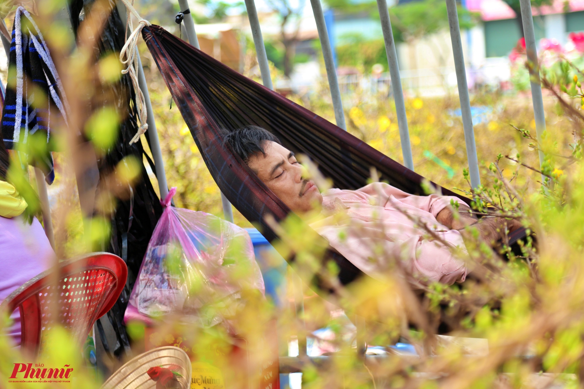 Một người đàn ông tranh thủ chợt mắt giữa cái nắng oi ả của Sài Gòn sau khi vận chuyển hoa 