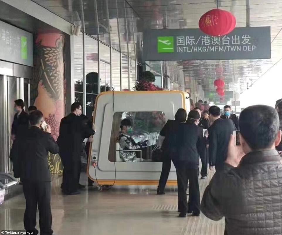 Một hành khách từ Vũ Hán được đưa khỏi sân bay trong buồng cách ly đặc biệt.