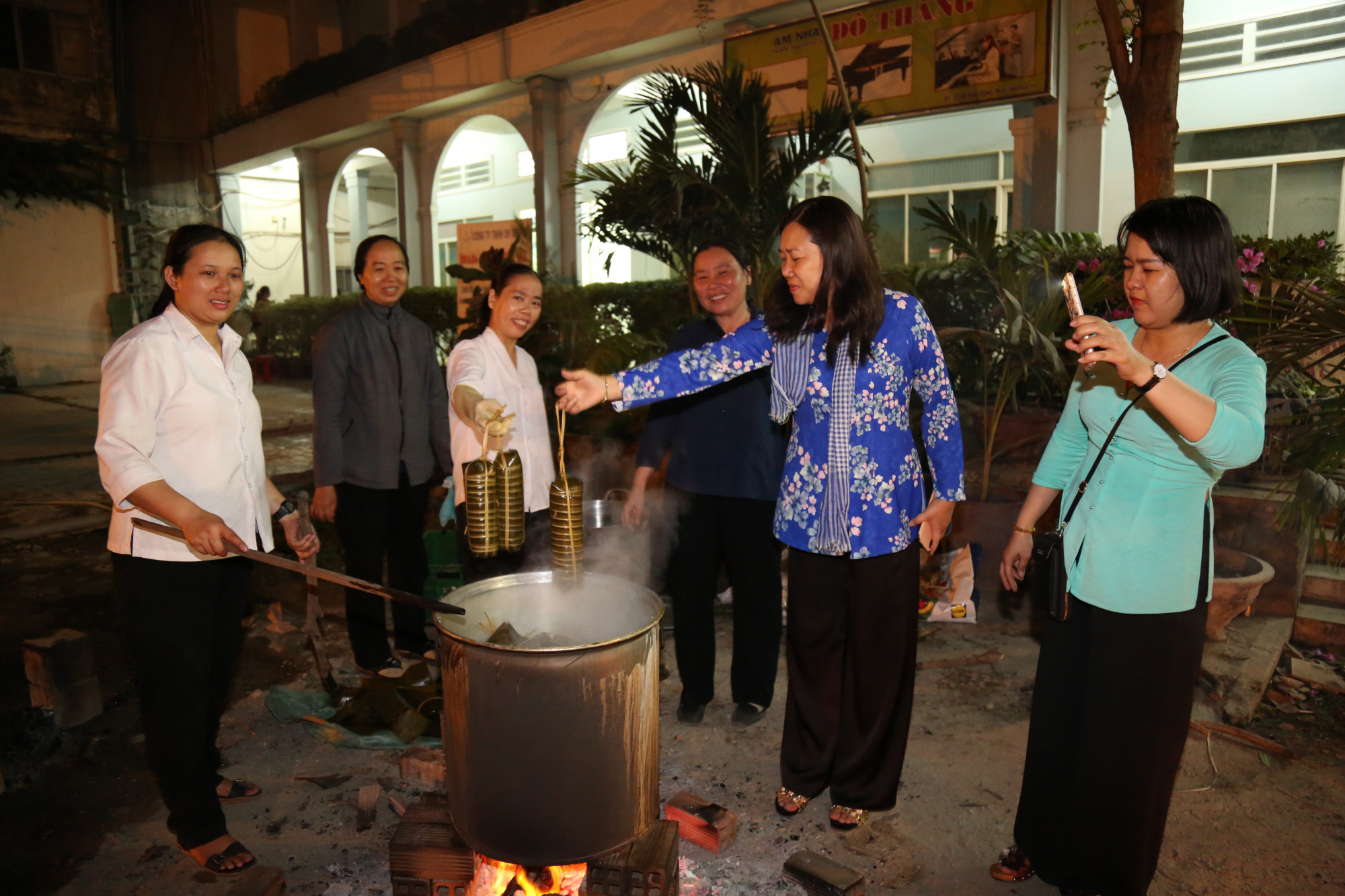 Bà Nguyễn Thị Tuyết Nga (thứ 2, từ phải qua) - Chủ tịch Hội LHPN quận 2 - cùng các sơ canh lửa, vớt bánh tét.