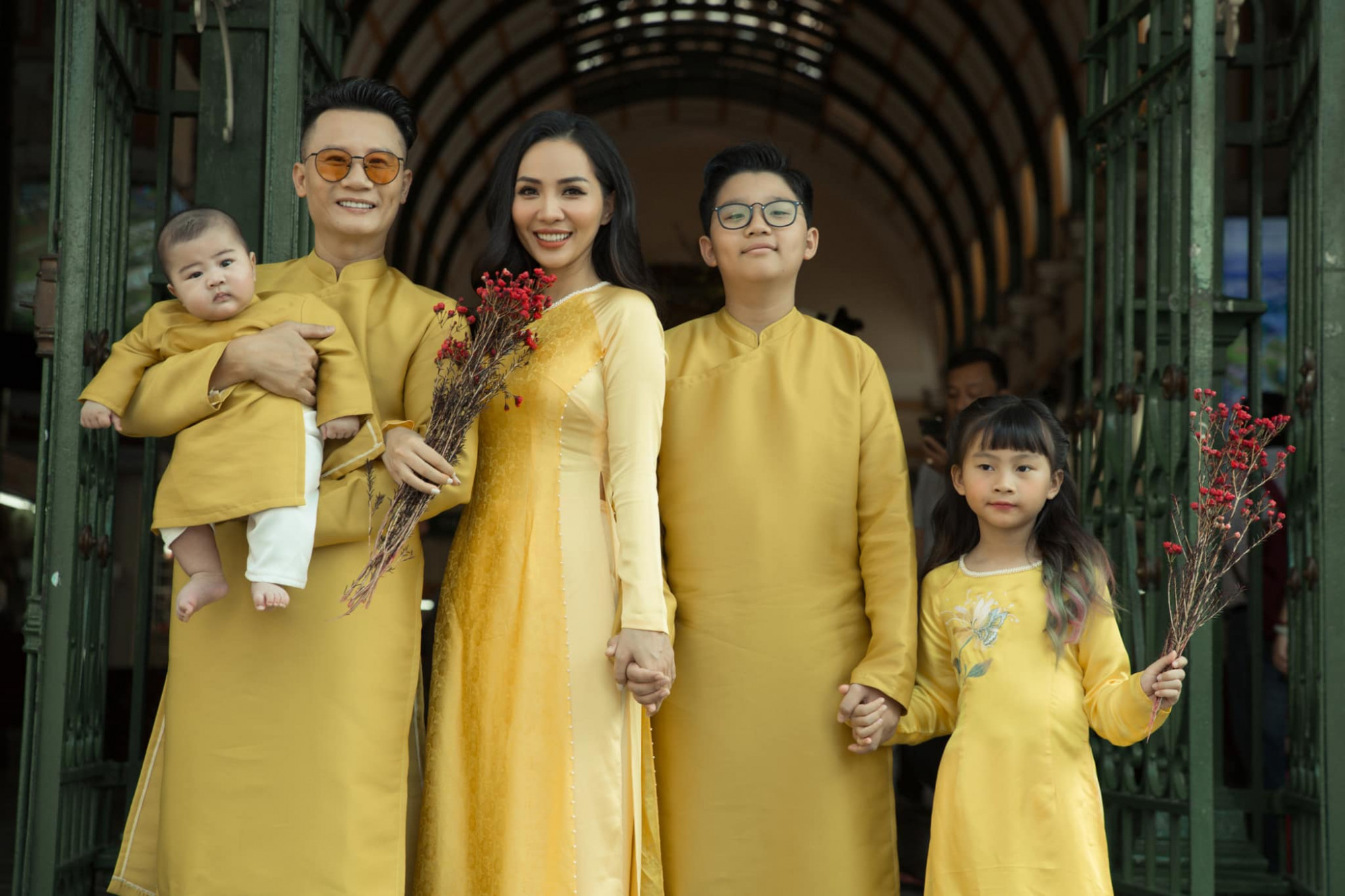 Gia đình ca sĩ Hoàng Bách diện áo dài tông xuyệt tông vàng bắt mắt.