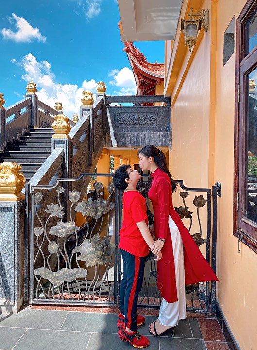 Trương Quỳnh Anh đi lễ chùa đầu năm với con trai trong tà áo dài đỏ rực, thiết kế tối giản.