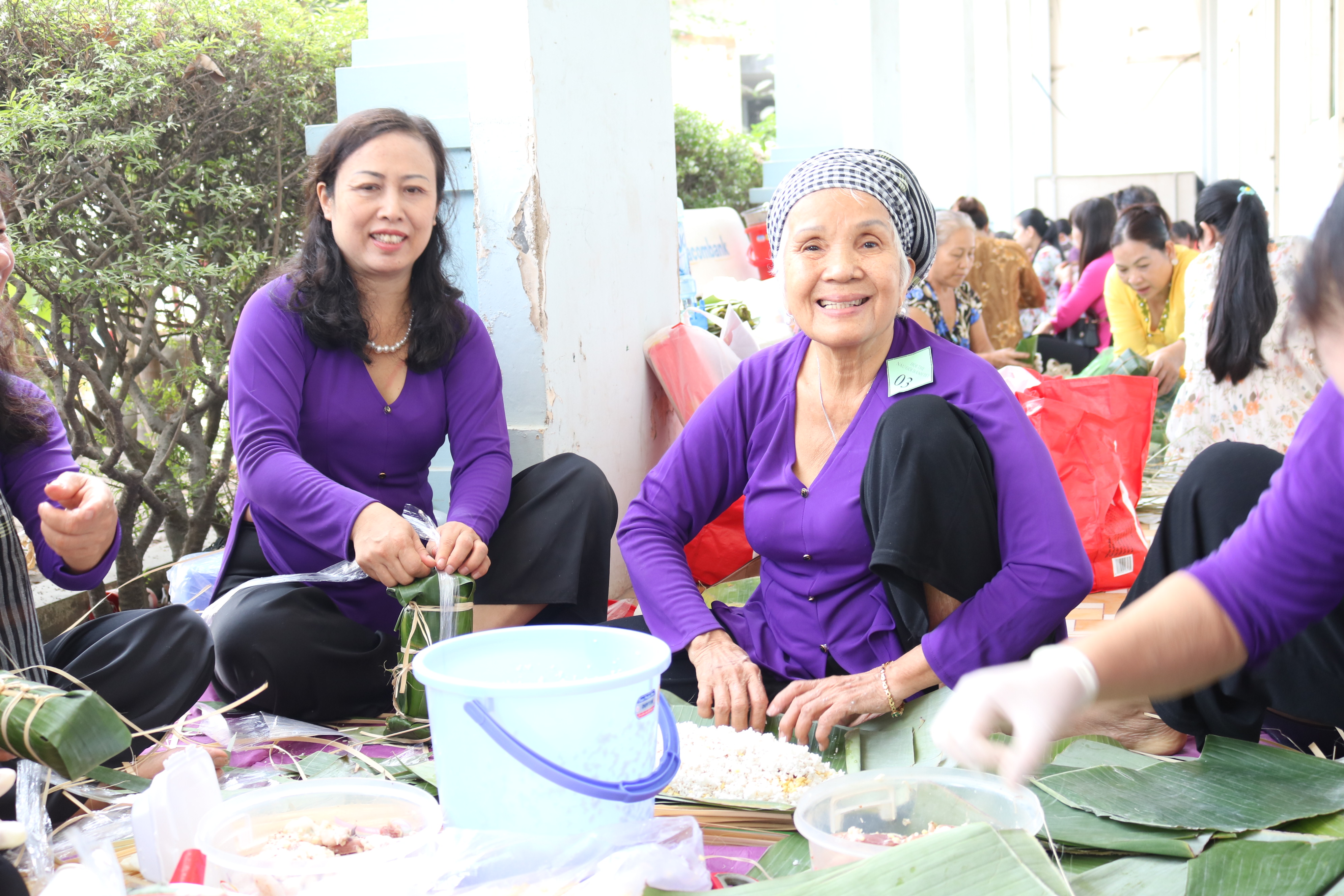 74 tuổi, dì Hồng (bìa phải) vẫn lui cui ngồi gói bánh tét. 