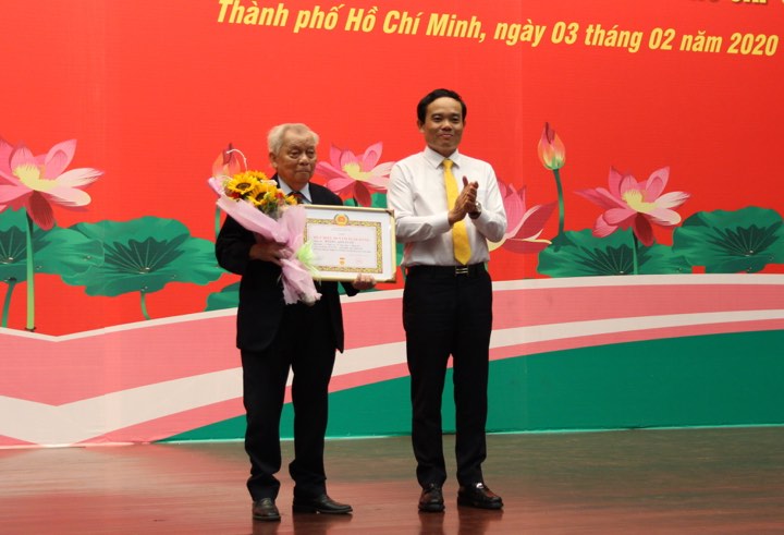 Ông Trần Lưu Quang - Phó bí thư thường trực thành ủy thành phố Hồ Chí Minh - trân trọng trao Huy hiệu 60 năm tuổi Đảng cho ông Hoàng Anh Tuấn
