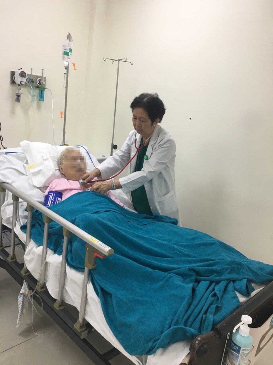  Bác sĩ Lê Kim Hà sửa áo, đắp mền cho bệnh nhân trong lúc khám bệnh