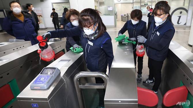 Nhân viên tàu điện ngầm Hàn Quốc xịt thuốc khử trùng phòng ngừa virus corona. Ảnh: AFP
