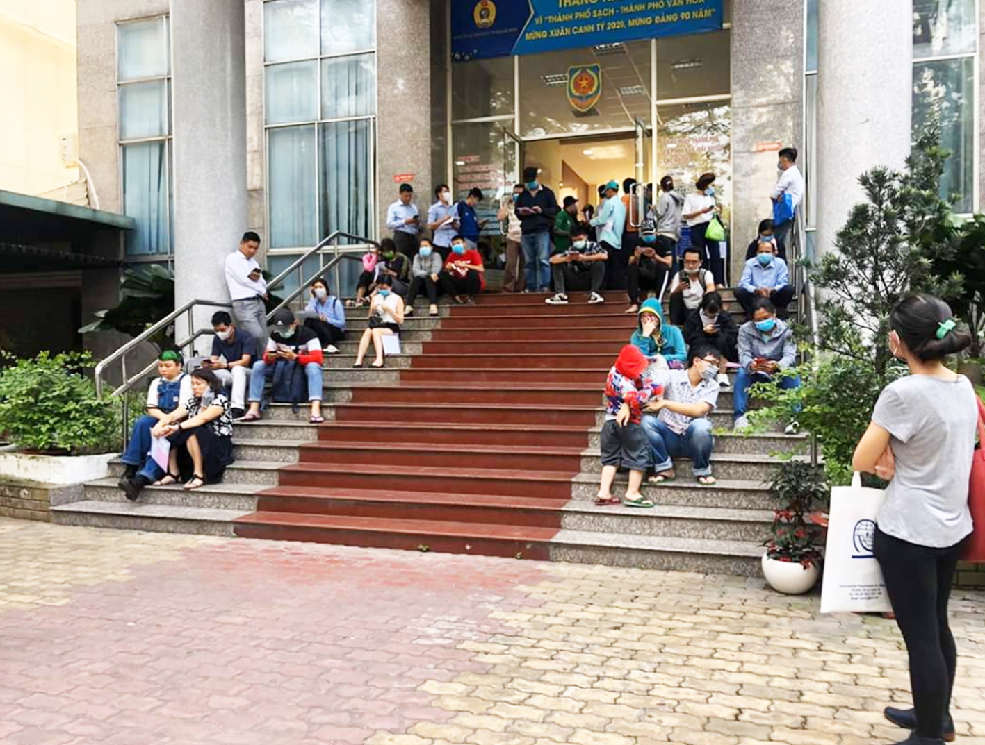 Người dân ngồi tràn bậc cầu thang cổng chính Sở Tư pháp TP.HCM chờ làm thủ tục