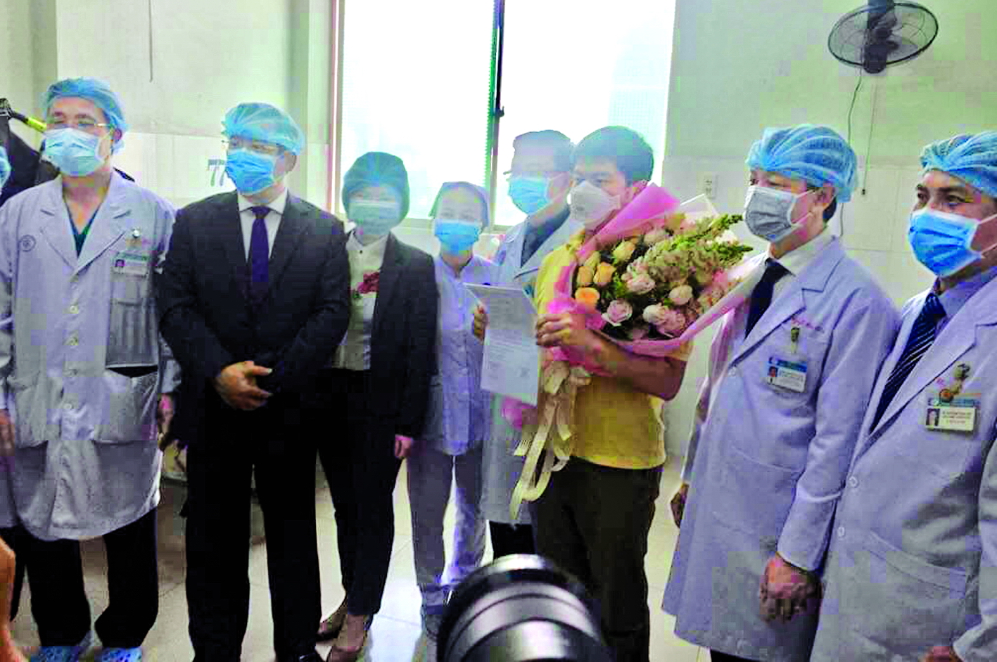 Các y bác sĩ chúc mừng bệnh nhân Trung Quốc đã chữa khỏi bệnh viêm phổi Vũ Hán và được xuất viện tại Bệnh viện Chợ Rẫy ngày 4/2 (bệnh nhân ôm hoa)