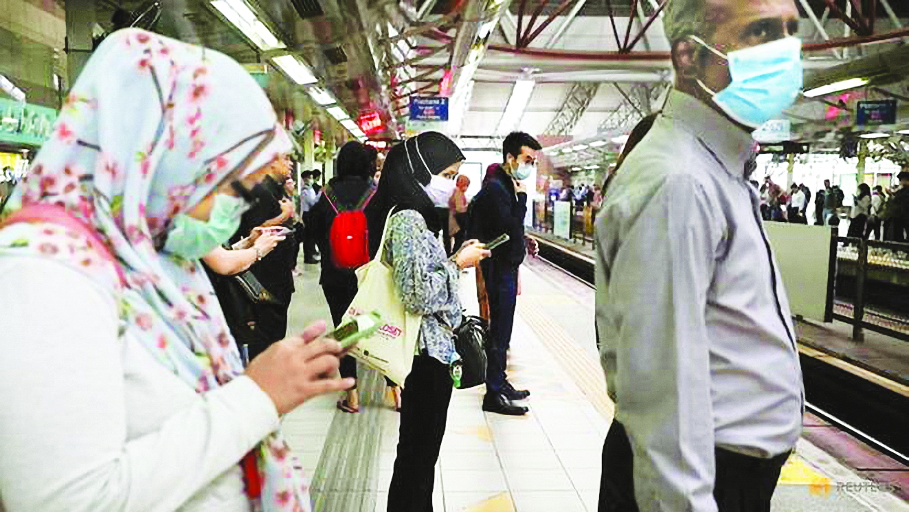 Hành khách đeo khẩu trang bảo vệ ở sân bay Malaysia - Ảnh: Reuters