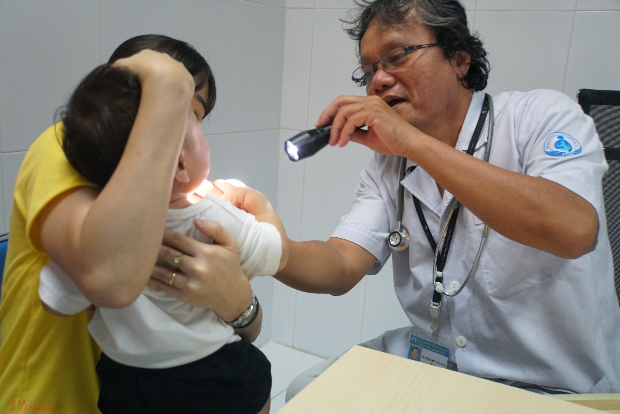 Bác sĩ Trương Hữu Khanh đang khám bệnh thông thường cho trẻ.