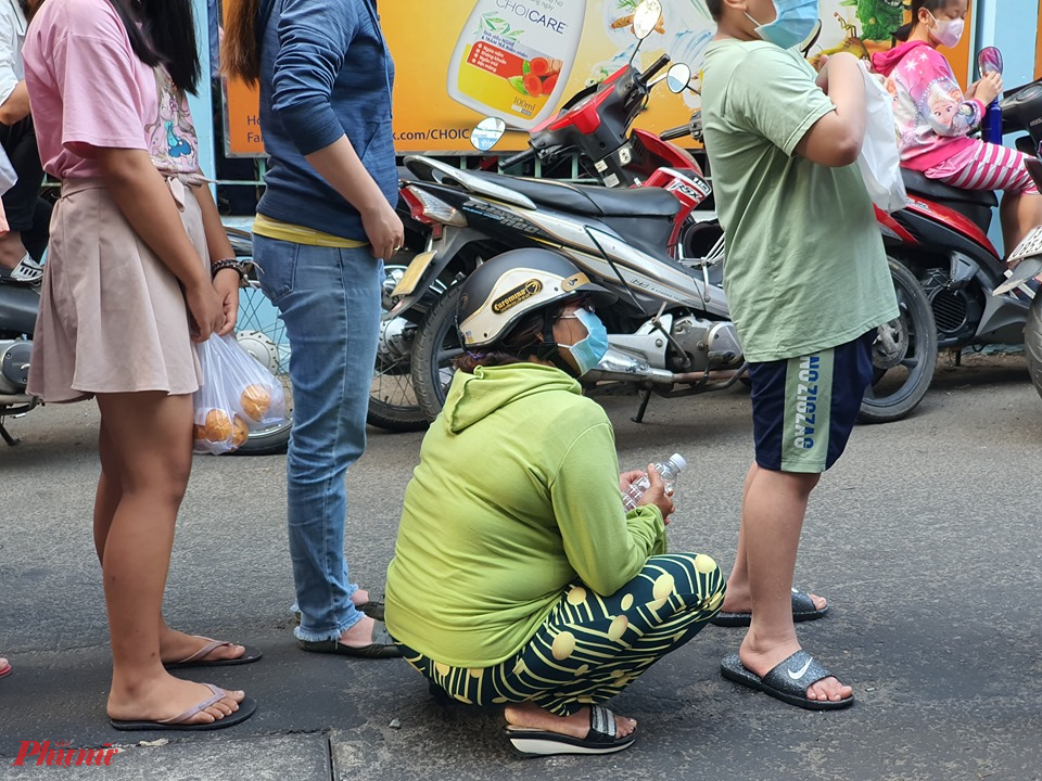 Hơn 8 giờ, nhiều người vẫn còn đợi với hy vọng cửa hàng... thương tình bán tiếp vài hộp khẩu trang và nước rửa tay, có người quá mệt mỏi ngồi đợi đến lượt mua.