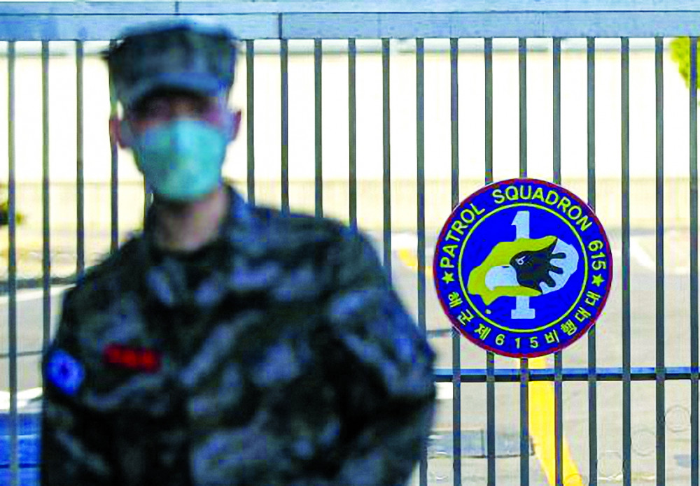 Một lính thủy Hàn Quốc đeo khẩu trang đứng trước căn cứ hải quân trên đảo Jeju hôm 21/2, sau khi một người lính của đơn vị được xác nhận bị nhiễm COVID-19  Ảnh: AP