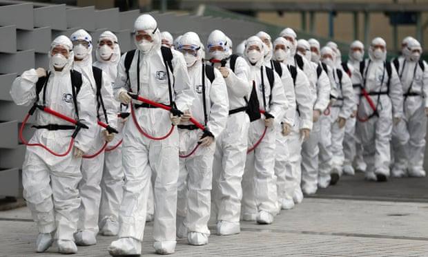 0Binh lính Hàn Quốc mặt đồ bảo hộ đi phun thuốc khử trùng tại Daegu. (Ảnh: AFP