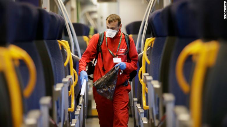 Công nhân đang làm vệ sinh bên toa tàu chạy khu vực Milan - Ảnh: CNN/Getty Images
