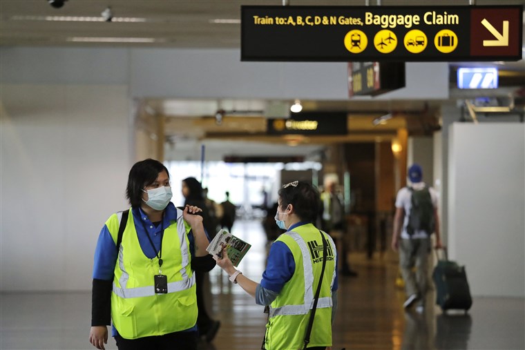 Nhân viên sân bay quốc tế Seattle-Tacoma đeo khẩu trang làm việc tại sân bay - Ảnh: AP