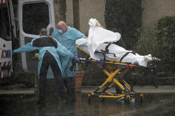 Nhân viên y tế tại thành phố Kirkland, bang Washington, Mỹ, đưa bệnh nhân COVID-19 đến bệnh viện hôm 7-3 - Ảnh: REUTERS
