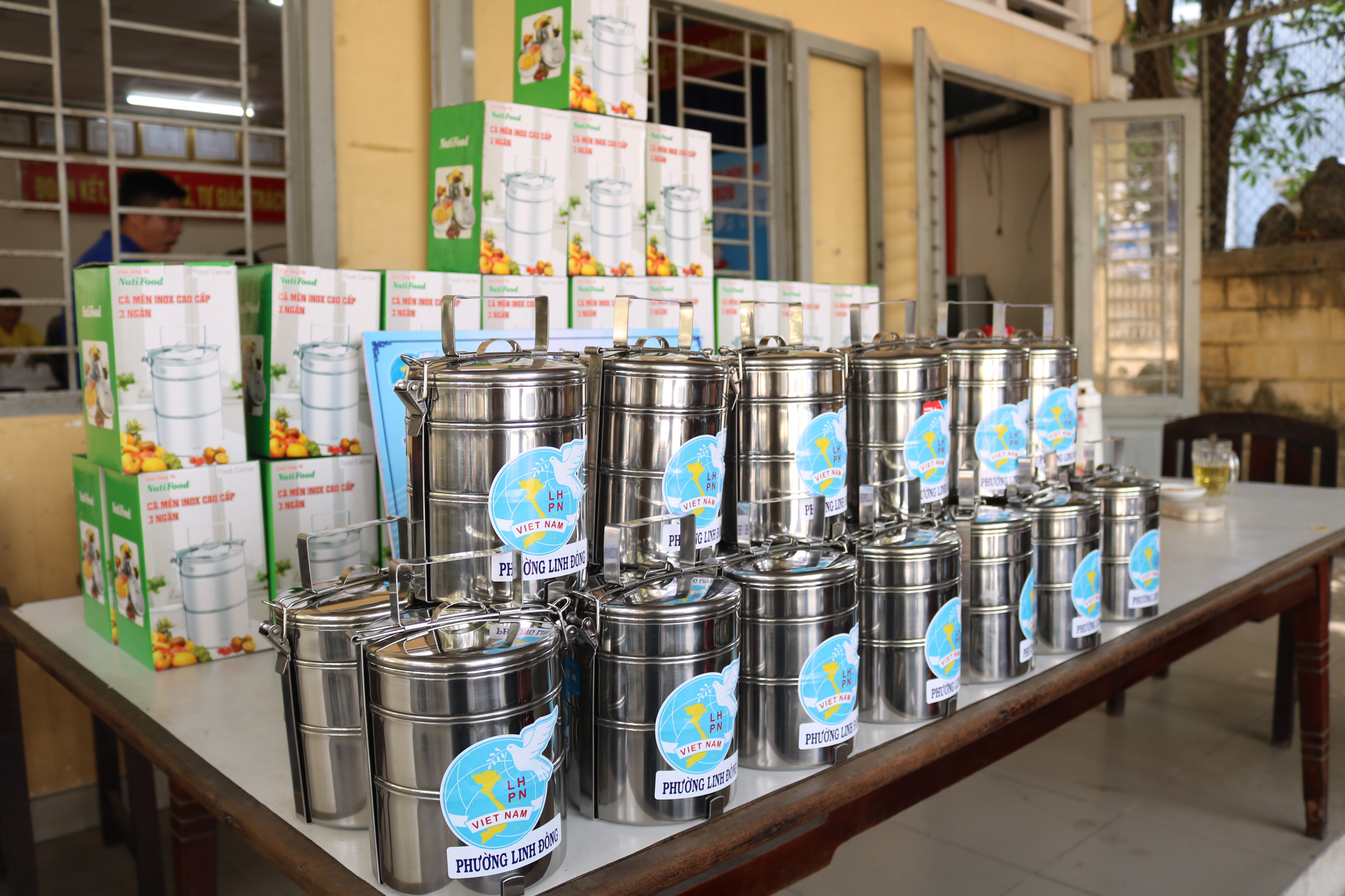 Hội Phụ nữ phường Linh Đông mua cà mèn inox tặng người dân đến nhận cơm. 