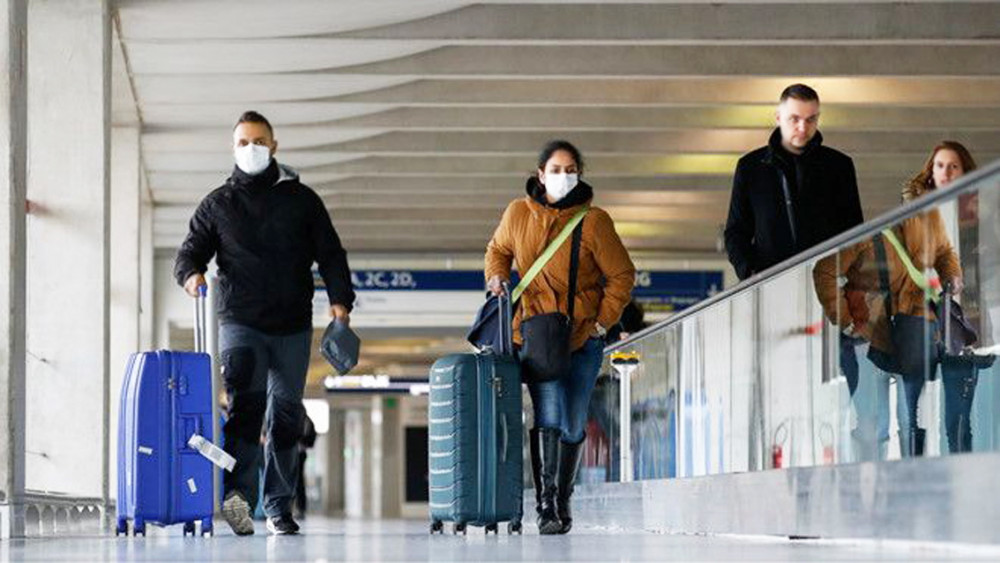 Hành khách đeo khẩu trang tại sân bay Charles de Gaulle, Pháp - Ảnh: Reuters