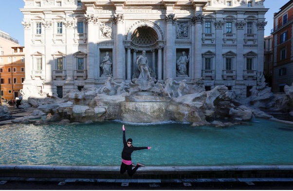 Một nữ du khách thích thú tận hưởng sự vắng vẻ khác thường của đài phun nước Trevi nổi tiếng ổ Rome.