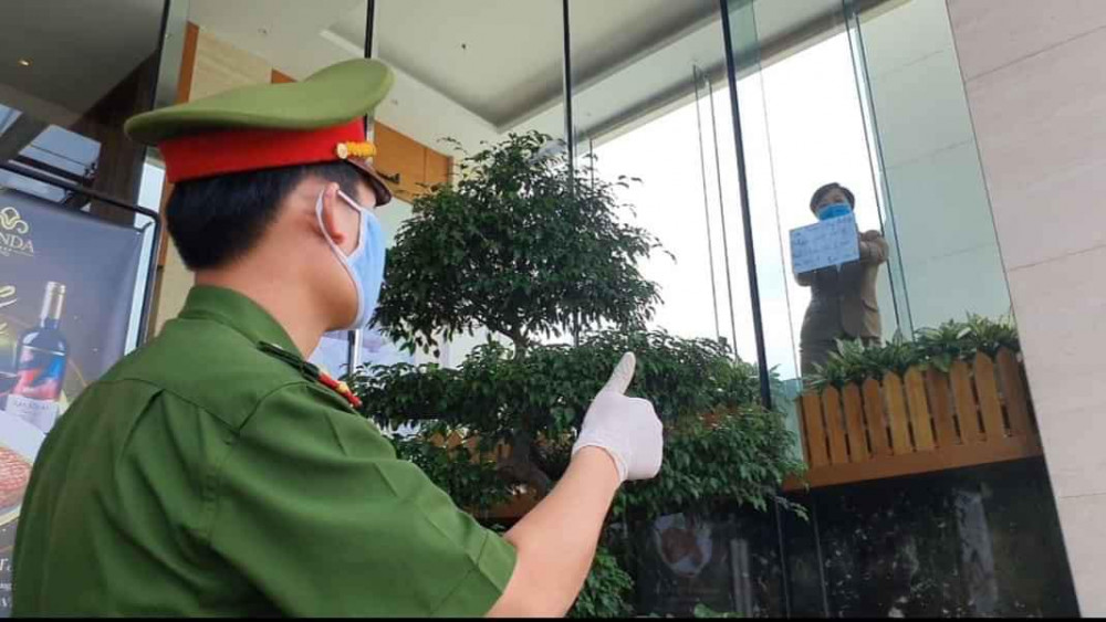 Người đang được cách ly trong khách sạn Vanda (nơi cư trú của 2 bệnh nhân người Anh nhiễm COVID-19) trên đường Nguyễn Hữu Linh trao đổi nhờ công an đang làm nhiệm vụ bảo vệ mục tiêu mua thức ăn