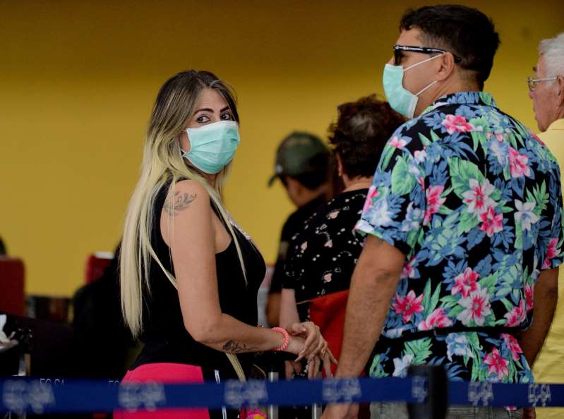 Du khách đeo khẩu trang tại Sân bay Quốc tế José Martí ở Havana. Ảnh: AFP