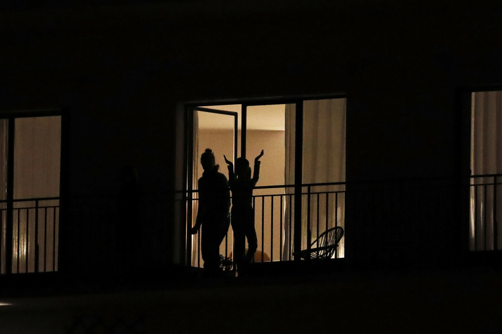 Từ một sáng kiến trên mạng xã hội, lúc 20 giờ mỗi đêm ở Pháp, nhiều công dân đã nghiêng mình từ cửa sổ, hay ra đứng trên ban-công nhà mình để cùng bắt đầu vỗ tay và phối hợp huýt gió, thể hiệnsự cảm ơn đội ngũ nhân viên y tế đang vất vả cứu người trong cơn đại dịch COVID-19. Ảnh: Christophe Ena (AP Photo).