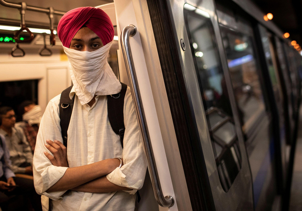 Một người Ấn Độ đeo khăn tay thay thế khẩu trang khi đi tàu điện ngầm. Ảnh: Danish Siddiqui, (Reuters).