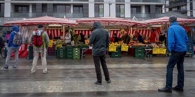 Người dân giữ khoảng cách khi xếp hàng mua bán tại một chợ nhỏ ở Frankfurt (Đức) hôm 21/3 - Ảnh: AP