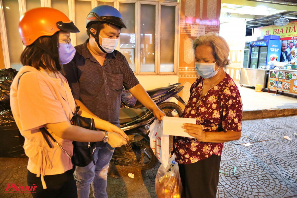 Một cụ bà nhặt ve chai trên đường Nguyễn Thị Minh Khai bất ngờ nhận được món quà của Báo Phụ Nữ. Hỏi về công việc của mình, bà nói: “Dịch bệnh, hàng quán đóng cửa hết rồi nên tối này chẳng nhận được gì cả”.