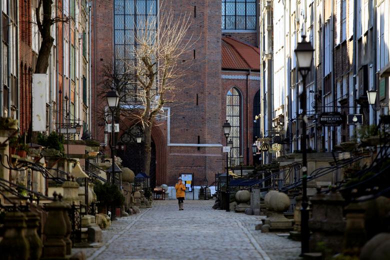 Main Town ở Gdansk, Ba Lan là nơi thường xuyên đông đúc nhưng từ khi dịch bệnh bùng phát đã trở nên vắng lặng hẳn. Một người phụ nữ đi qua con phố vào ngày 23/3 không có một bóng người.