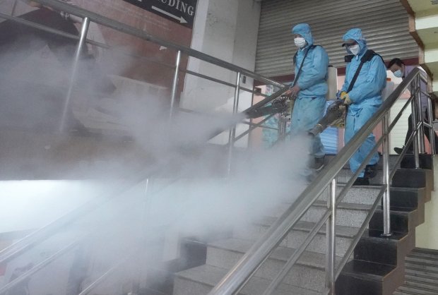 Nhân viên dịch tễ khử trùng lối vào một trung tâm mau sắm tại Vũ Hán.