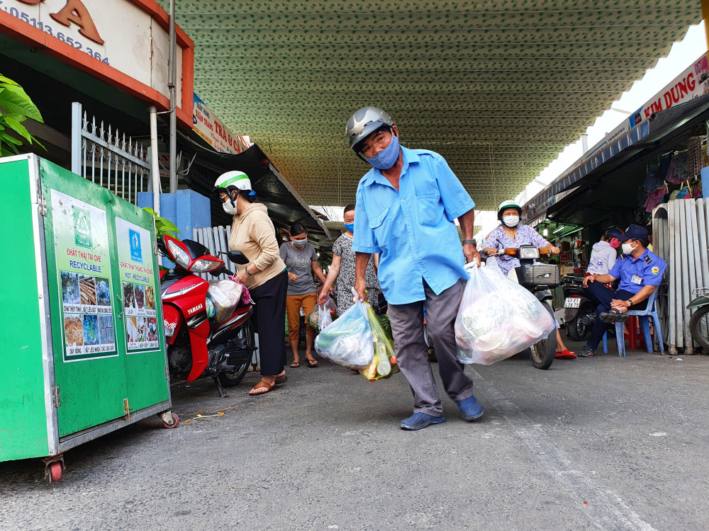 Một người đàn ông phụ vợ xách thực phẩm về nhà