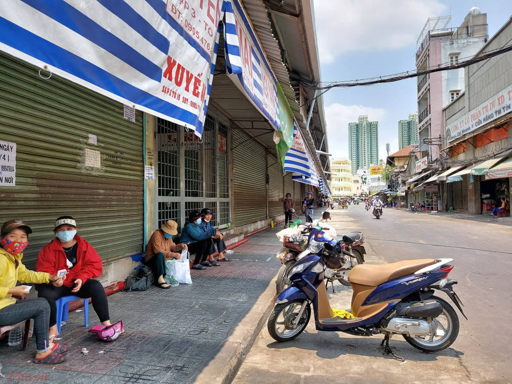 Các cửa hàng ở chợ Kim Biên đóng cửa, nhiều người tận dụng mái hiên trong chợ làm nơi nghỉ mát giữa trưa.