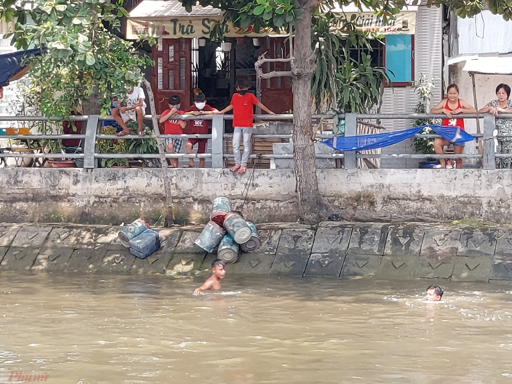 Khách đi đò bất bình trước cảnh trẻ em tắm sống mùa dịch nhưng người dân địa phương thì tỏ ra bình thường, đứng im trên bờ xem trẻ em tắm sông.