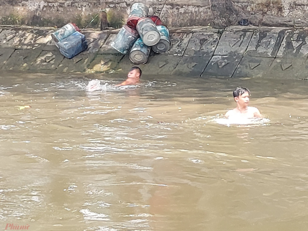 Gần 12 giờ trưa, cảnh tượng trẻ tắm sông Phú Định vẫn tiếp diễn.