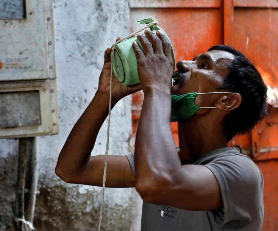 Một công nhân nghèo đang hứng nước miễn phí để giải toà cơn khát