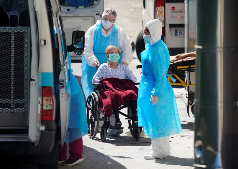 Nhân viên y tế đang đưa môt cụ bà ngồi xe lăn ở viện dưỡng lão Leganes Madrid, Madrid, Tây Ban Nha đến bệnh viện để xét nghiệm vào ngày 2/4.
