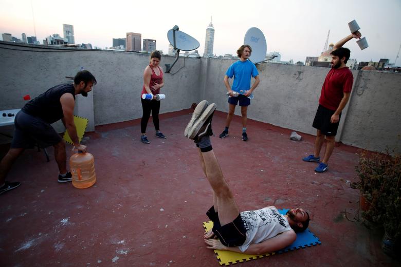 Một nhóm thanh niên tập gym trên sân thượng của một khu chung cư tại thủ đô Mexico vào chiều 27/3.