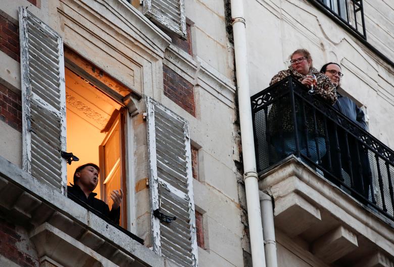 Ca sĩ Stephane Senechal hát từ cửa sổ của căn hộ để giải toả tinh thần cho hàng xóm tại thủ đô Paris hôm 24/3.