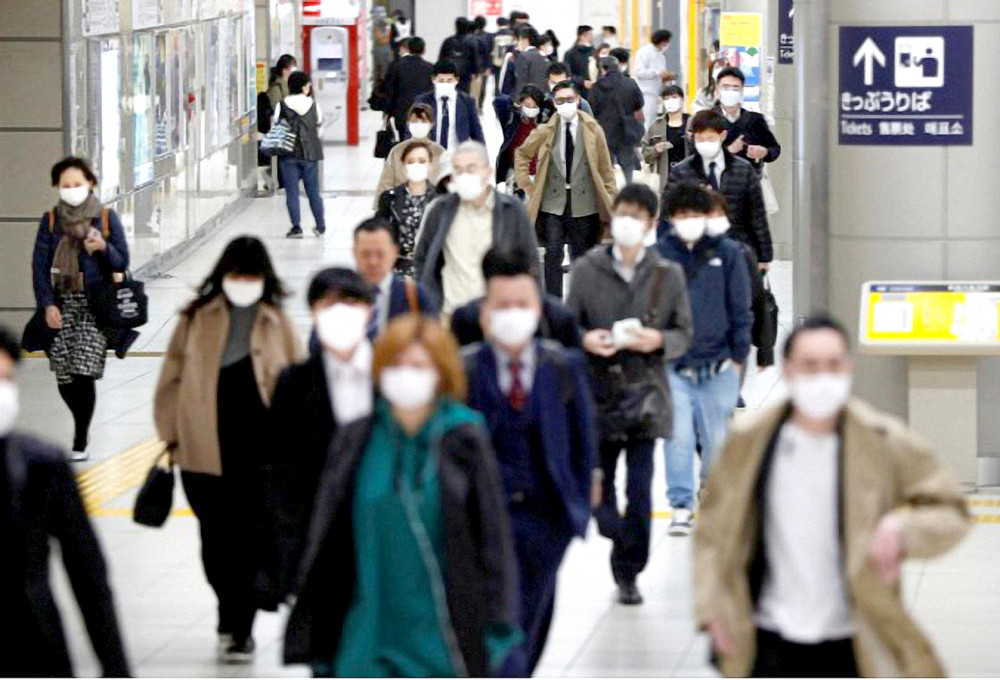 Người dân Tokyo chấp hành khuyến cáo đeo khẩu trang khi đi làm vào sáng 7/4 - Ảnh: Reuters