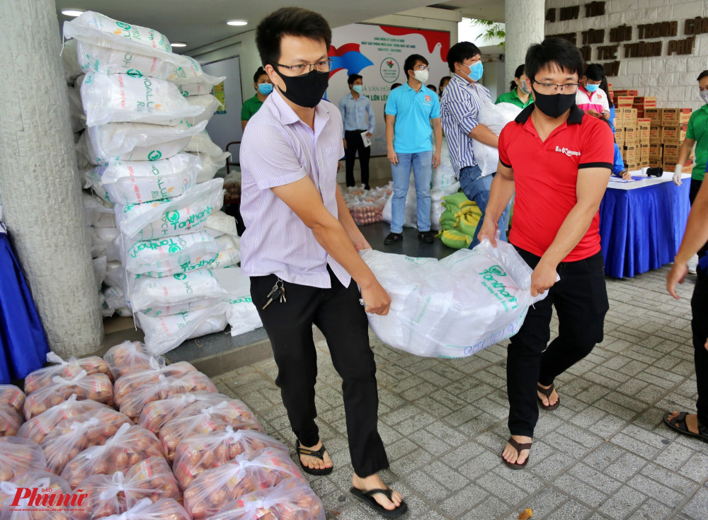 Các tình nguyện viên vận chuyển gạo lên xe chuyển đến người dân 24 quận huyện trên địa bàn thành phố