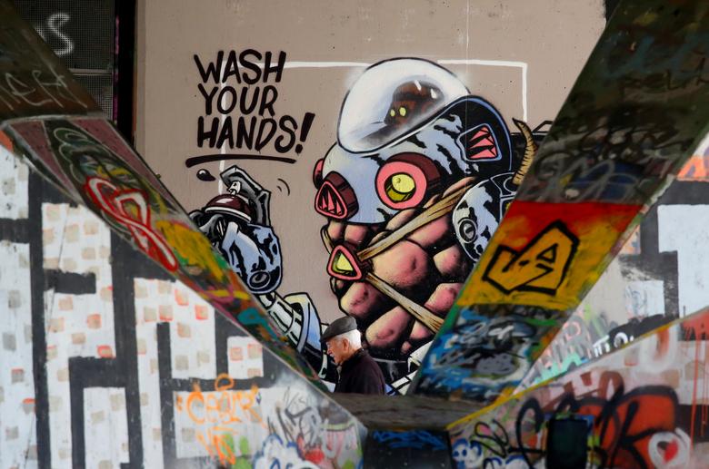 Người đàn ông đang hoàn thành bức tranh graffiti với nhiều thông điệp khác nhau bên dưới một cây cầu ở Vienna, Áo. Trong đó, nổi bật lên dòng chữ 