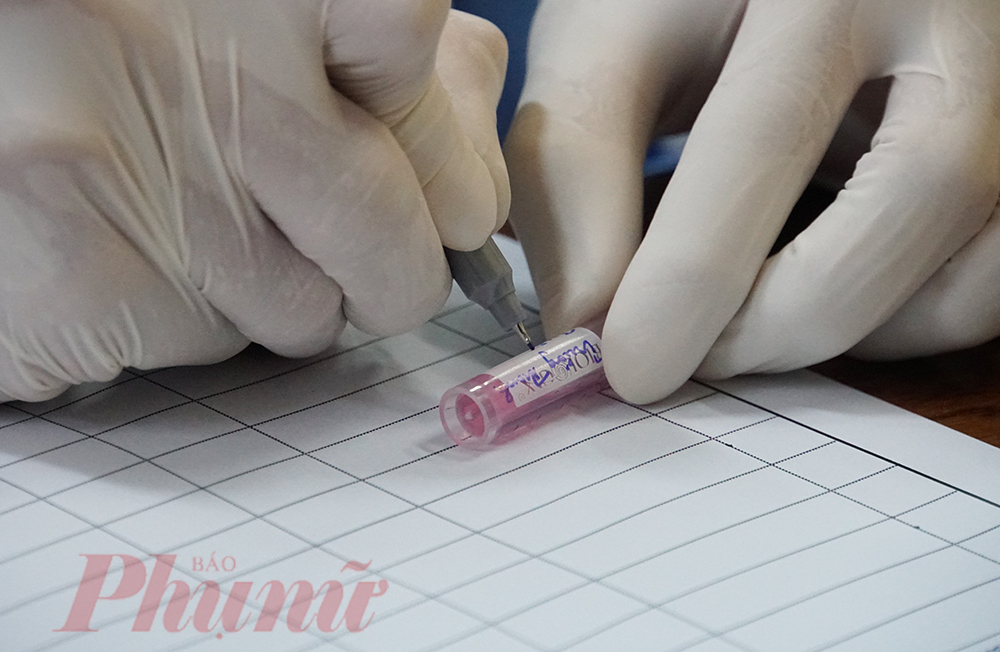 Nhân viên y tế chuẩn bị lấy mẫu xét nghiệm cho người nghi ngờ nhiễm COVID-19 tại Thảo Điền, Quận 2, TPHCM