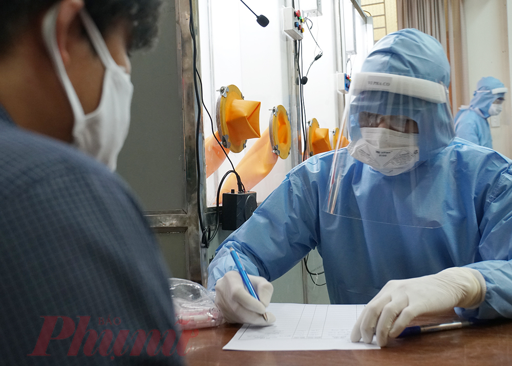 Nhân viên y tế tại Thảo Điền quận 2, TPHCM hỗ trợ người khai báo y tế.