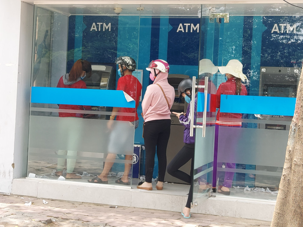 Các công nhân tranh thủ đến trụ ATM rút tiền trong ngày chủ nhật để tránh cảnh chen lấn