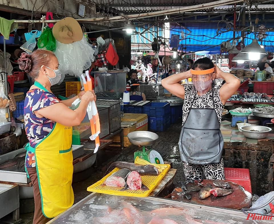 Tiểu thương chợ Linh Trung nhận tấm che mặt chắn giọt bắn phòng dịch COVID-19. 